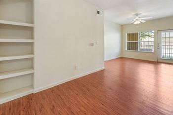 a living room with white walls and a wooden floor